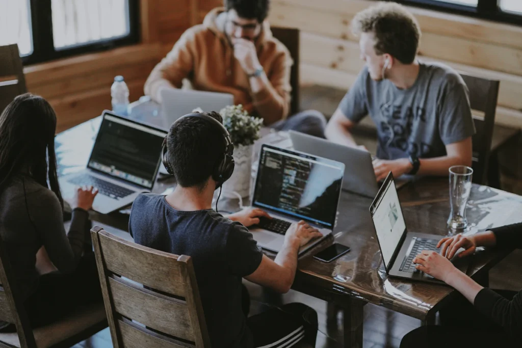 Colleagues collaborating around laptops in a shared office